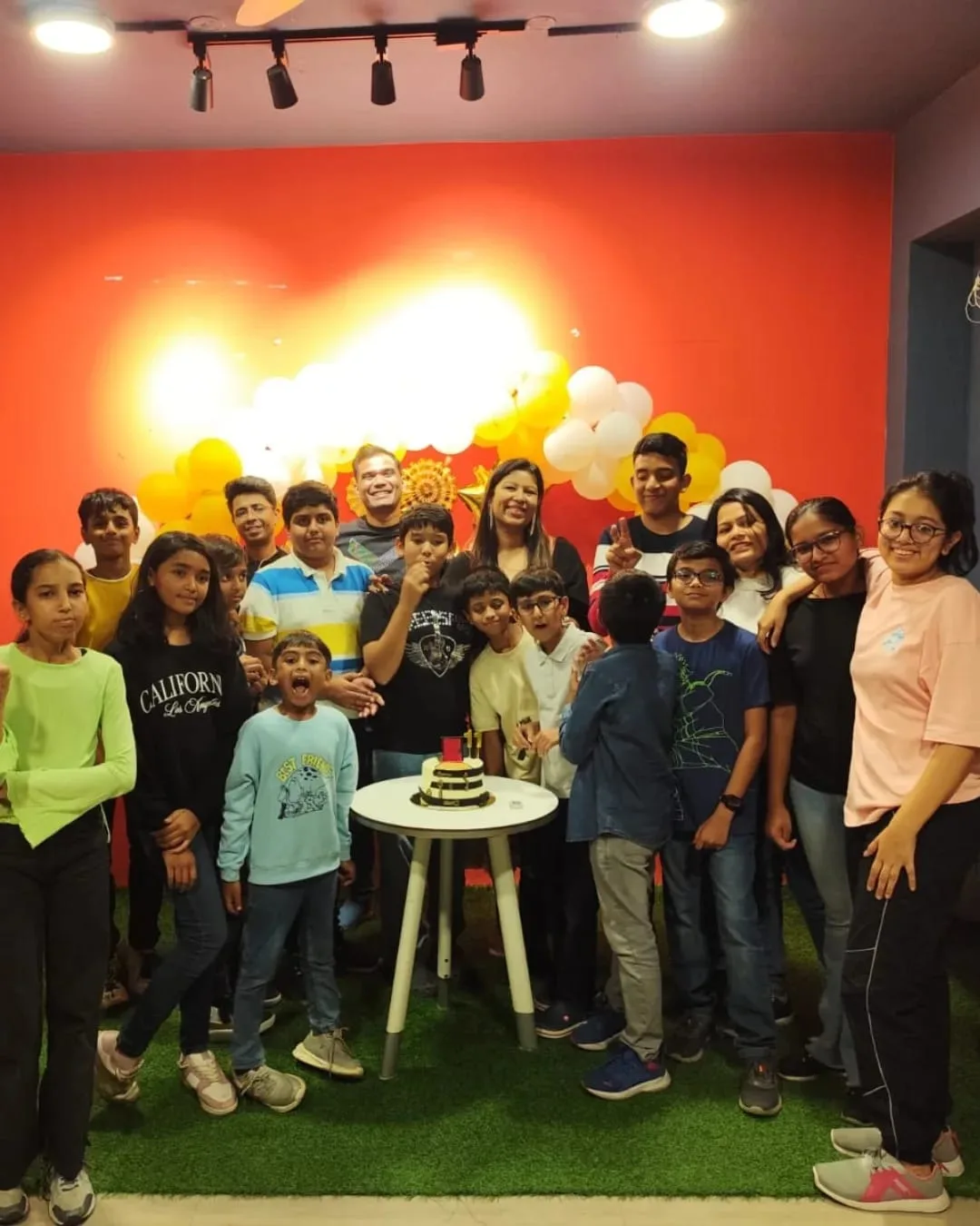 Children around the cake at a birthday party